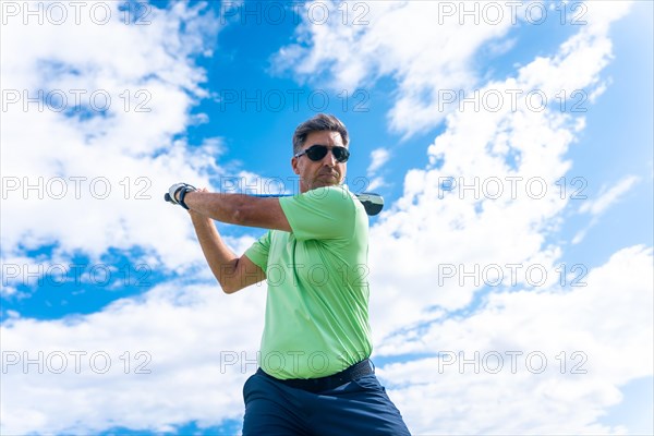 Male golf player on professional golf course hitting the ball with the stick driver