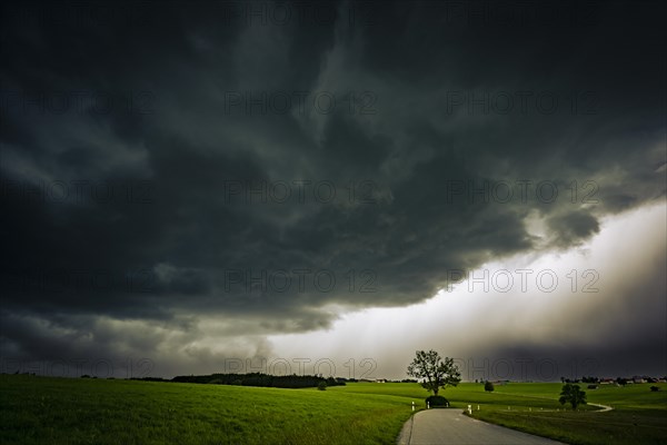 Road and meadows with thunderstorm sky in the background