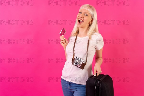 Very happy smiling tourist with passport and suitcase