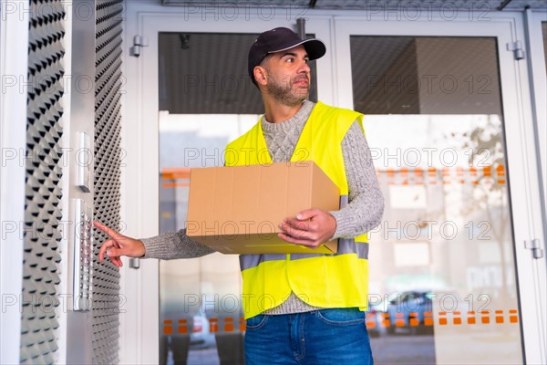 A young delivery man in a protective uniform delivering the online order in a home ringing the doorbell