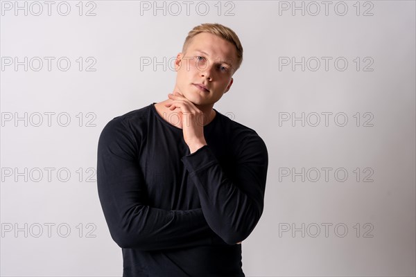 Attractive blonde german model in a black pullover on a white background