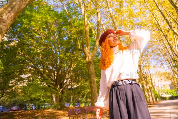 Portrait of red-haired woman with beret in a park