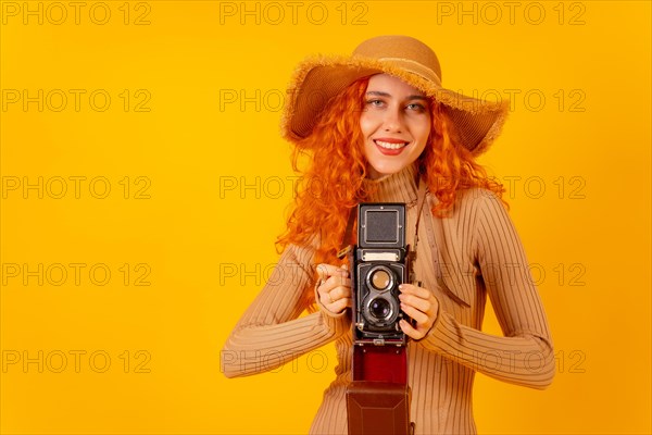 Red-haired woman tourist on a yellow background