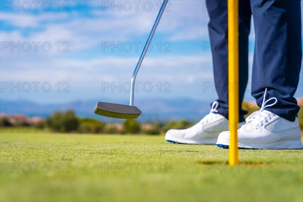 Hitting the green with the putter. The ball in the hole. man playing golf