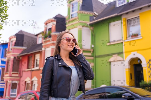 Young blonde woman in leather jacket walking visiting the neighborhood