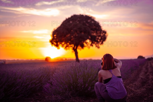 A woman at sunset in a lavender field with purple flowers