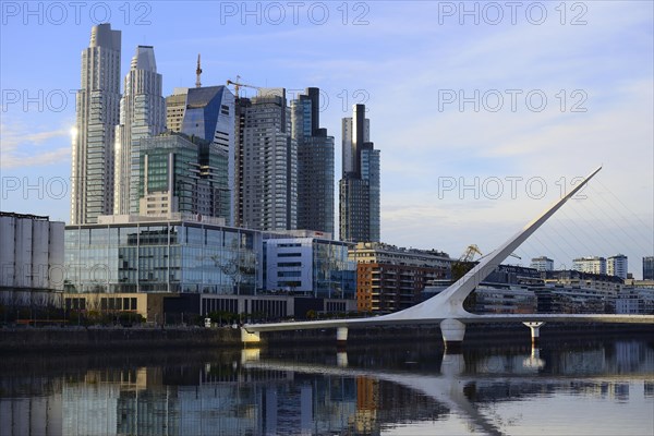 Skyscrapers and the Puente de la Mujer bridge reflected in the water