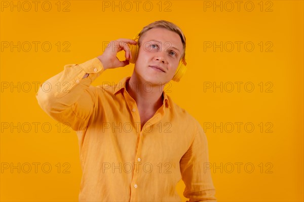 Young blond caucasian man on a yellow background