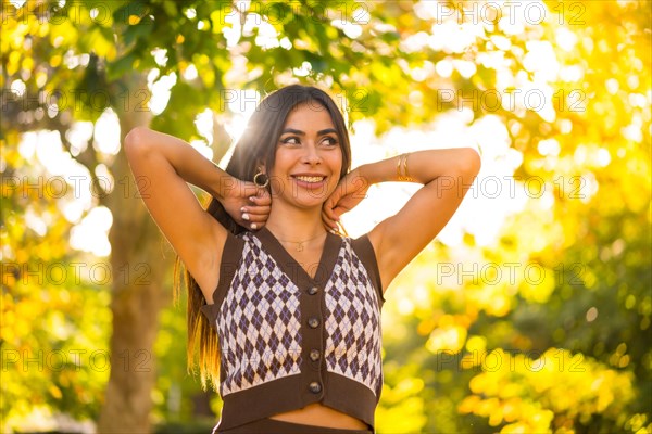 Portrait of a brunette model in autumn at sunset in a natural city park