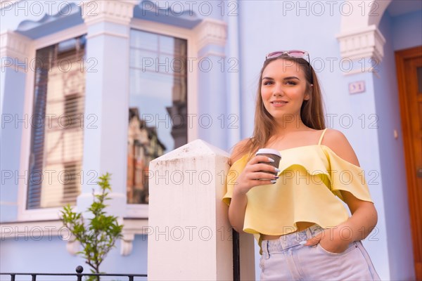 Young blonde in a neighborhood with houses with colorful facades