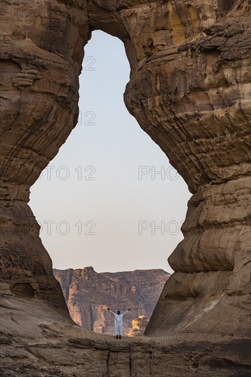 Man standing in a giant hole in the rock