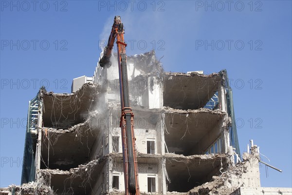 Demolition excavator and rubble of a demolished house