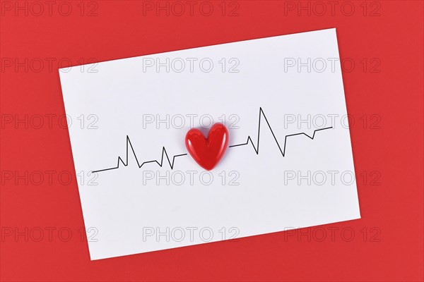 Heart and heartbeat line on white paper note on red background