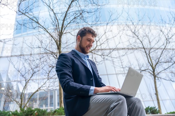 Young businessman or finance man looking at computer outside office
