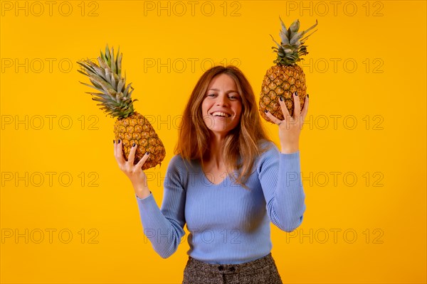 Vegetarian woman smiling with a cut pineapple