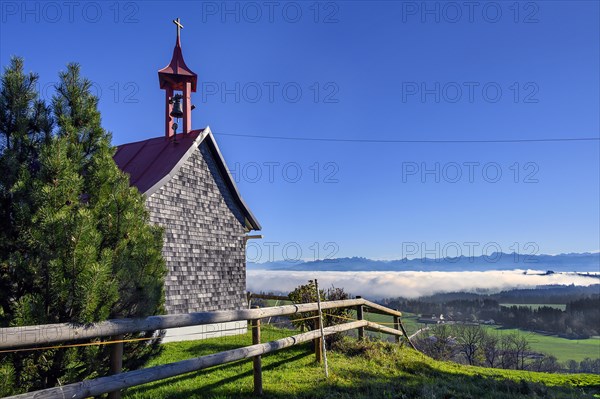 The small chapel of Eschachberg at Blender with a view of the Alps with clouds of mist near Kempten
