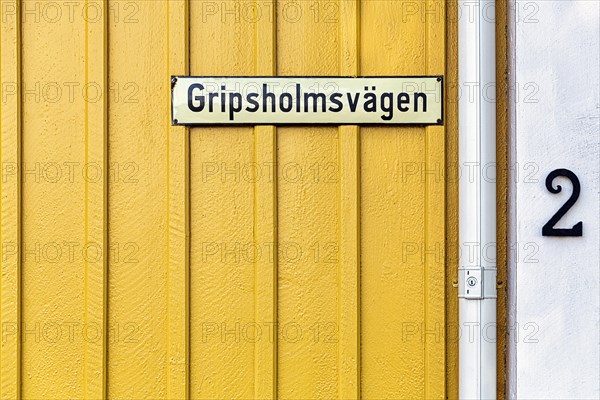 Street sign on a yellow painted wooden house