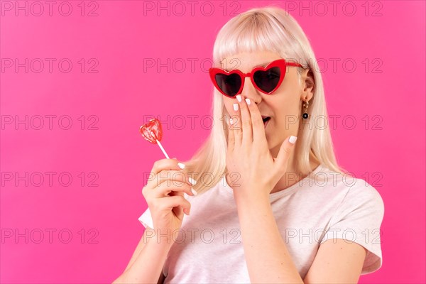 Blonde caucasian girl in studio on a pink background