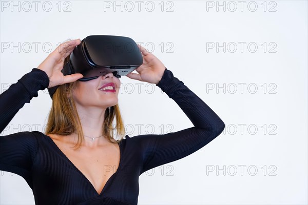 Woman wearing virtual reality goggles on white background