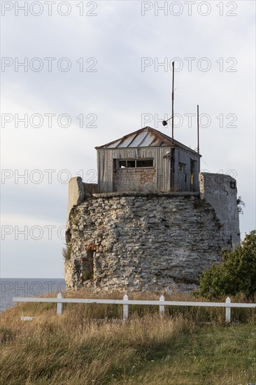 Ruin of the historic lighthouse in the evening light on the cliff on Pakri Peninsula