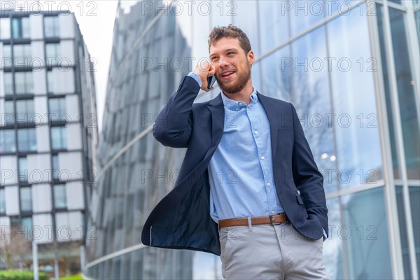 Young businessman or finance man talking on the phone outside the office