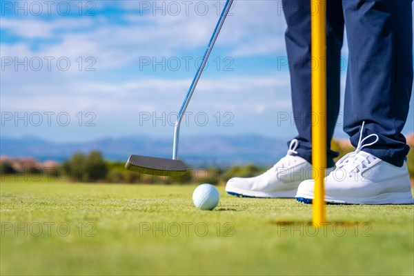 Hitting the green with the putter Putting the ball in the hole. man playing golf