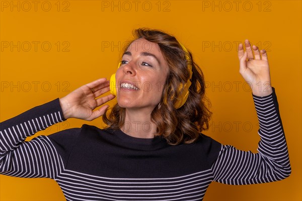 Portrait of a caucasian girl listening to streaming music and smiling and dancing with her phone