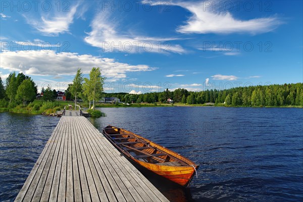 Lake with long jetty and wooden boat