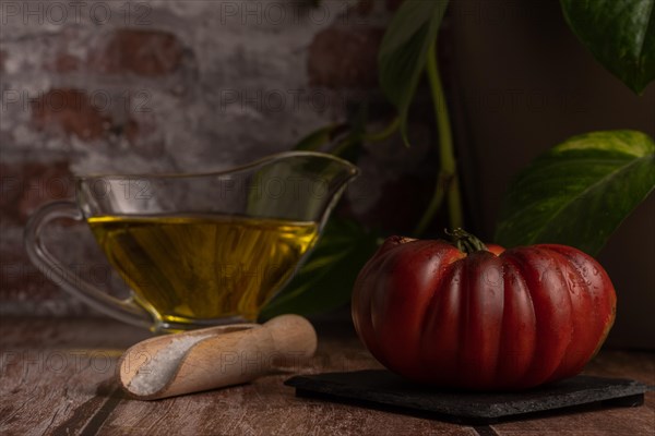 Chopped Moorish tomatoes with jar of olive oil and wooden spoon with salt