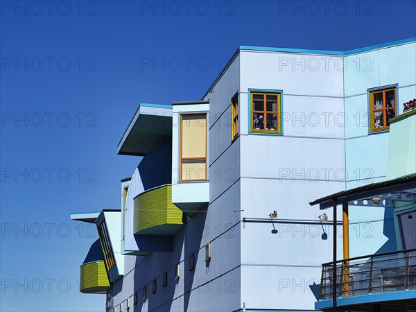 Light blue facade with colourful windows and balconies