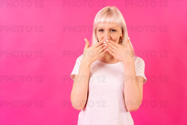 Blonde caucasian girl in studio on pink background