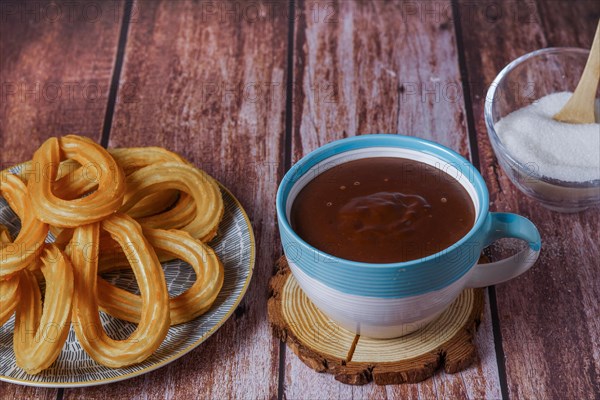 Hot chocolate with churros in a white and blue cup
