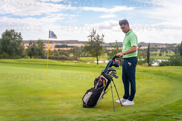 Caucasian professional golf player on a golf course on the green preparing for the shot