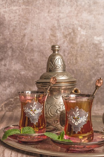 Tray with glasses and serving pitcher of authentic Moorish tea ready to drink with mint leaves