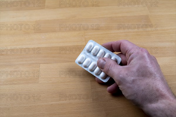 Male hand with a blister of tablets