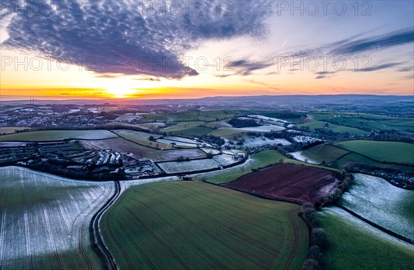 Sunset over Fields and Farms shrouded in frost from a drone