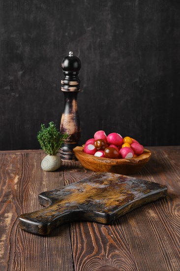 Rustic kitchen table with fresh vegetables and pepper mill blurred on background