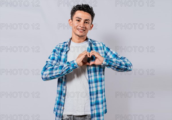 Smiling guy making heart shape with hands isolated. Happy man making heart shape with hands isolated. Person putting hands together in a heart shape