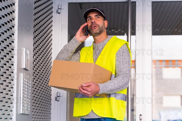 Young delivery man in protective uniform at online order delivery