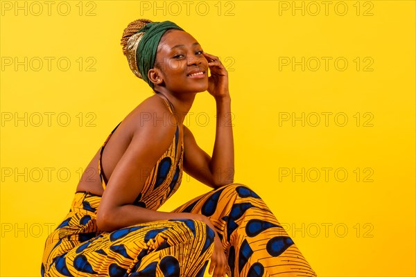 One person woman of black ethnicity with traditional costume on yellow background