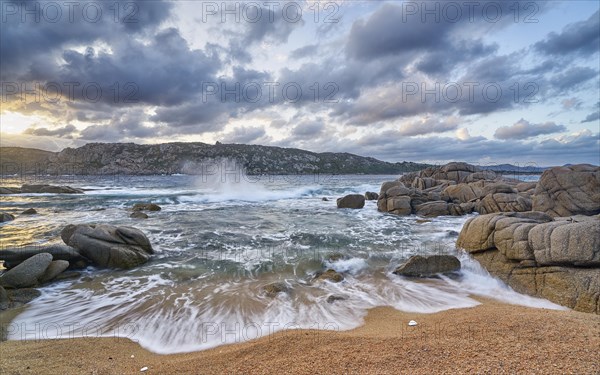 Surf with rocks and sandy beach