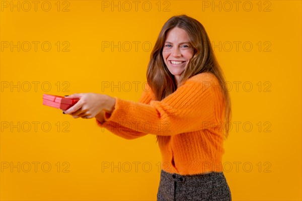 A woman delivering a gift as a surprise on a yellow background