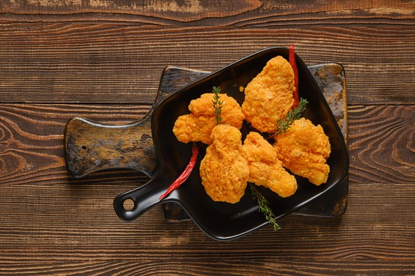 Top view of deep fried spicy chicken wings on wooden table closeup