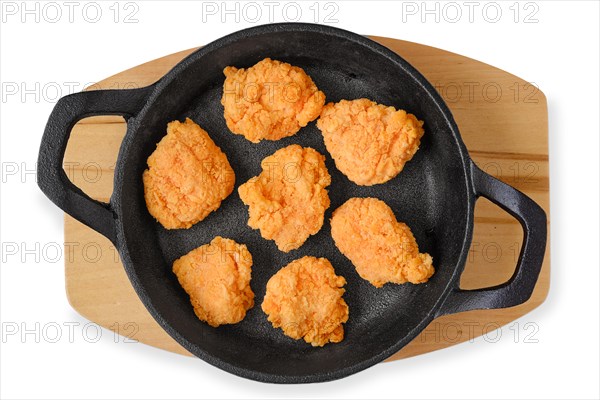 Top view of semifinished frozen chicken drumsticks in cast iron skillet