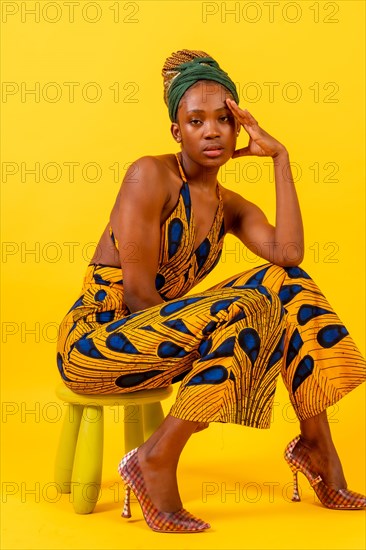 A person woman of black ethnicity with traditional costume in yellow background