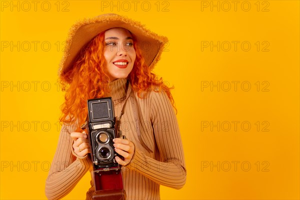 Red-haired woman tourist on a yellow background