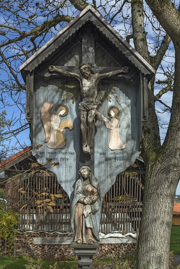 Christ cross in front of a farmhouse