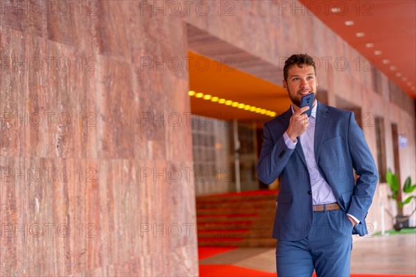 Business or finance corporate man at the entrance of an event in a hotel with the phone