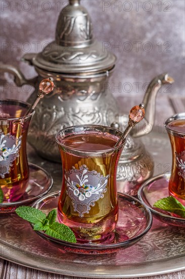 Tray with glasses and serving pitcher of authentic Moorish tea ready to drink with mint leaves