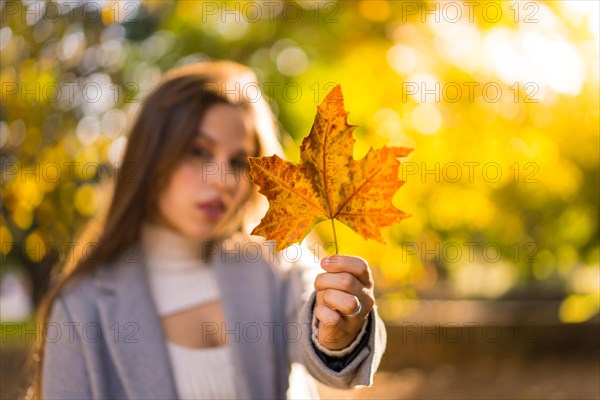 A pretty woman enjoying autumn in a park at sunset